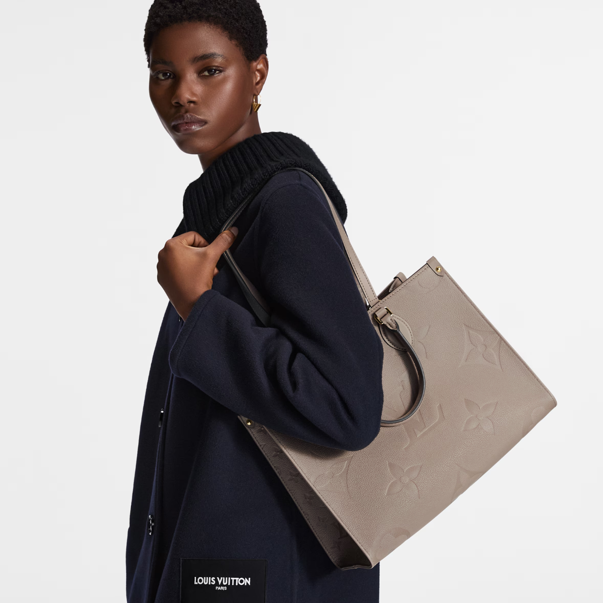 Onthego MM Beige – thanks to the square shape, it boasts a generous capacity and can easily fit a laptop – LUX VERSE Luxury Designer Fashion Outlet
