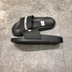 Schwarze Slides mit weißem Logo