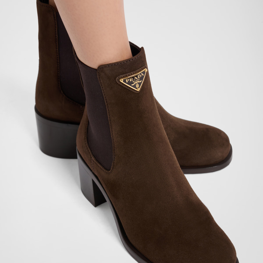 Suede booties – the enameled metal triangle logo embellishes the style with its sleek, distinctive – LUX VERSE Luxury Designer Fashion Outlet