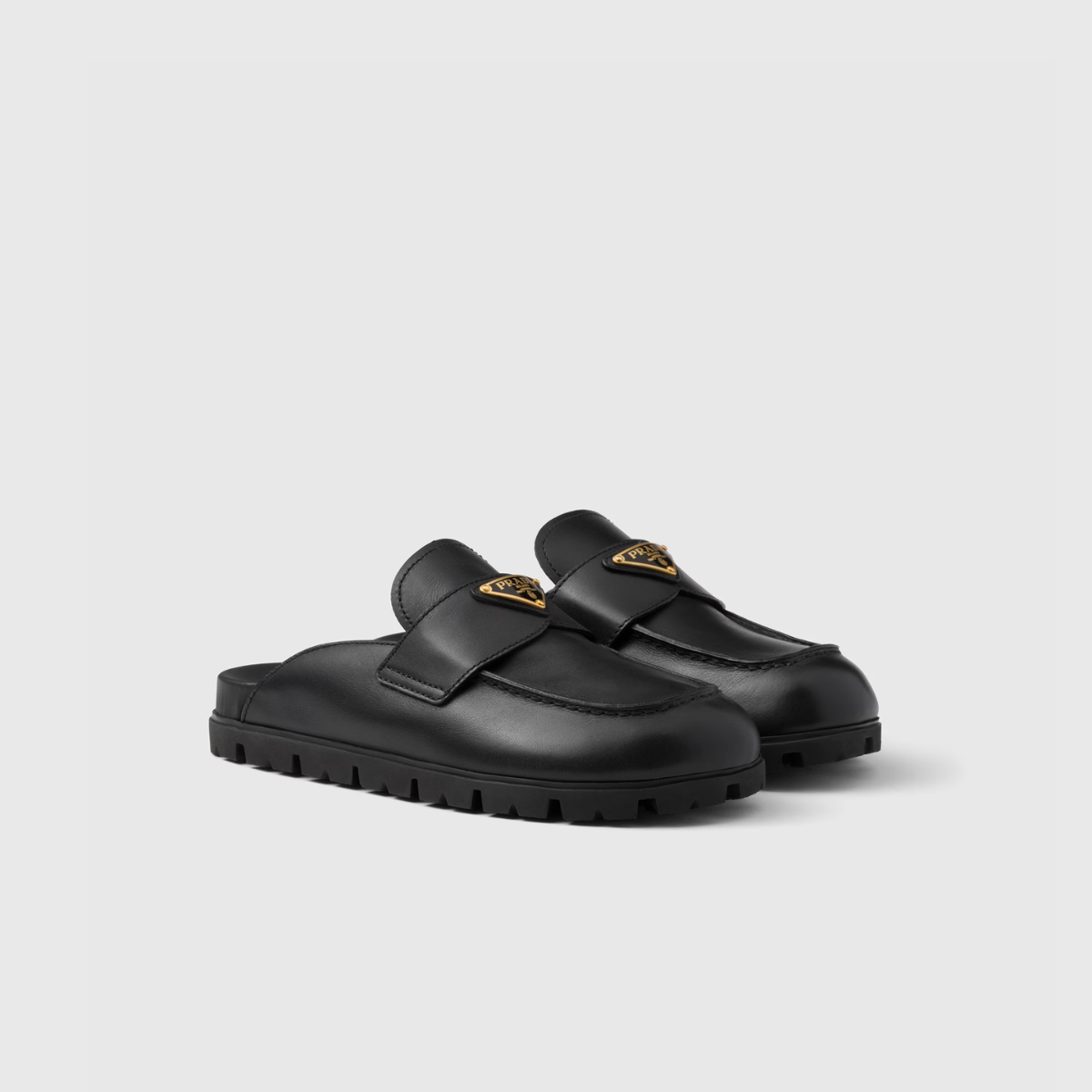 Leather mules – the enameled metal triangle logo embellishes the leather band while the light rubber – LUX VERSE Luxury Designer Fashion Outlet