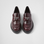 Chocolate brushed leather loafers – upper with leather strap Enameled metal triangle logo 50 mm rubber monobloc sole – LUX VERSE Luxury Designer Fashion Outlet