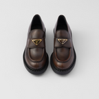 Chocolate leather loafers – the enameled metal triangle logo completes the iconic footwear – LUX VERSE Luxury Designer Fashion Outlet