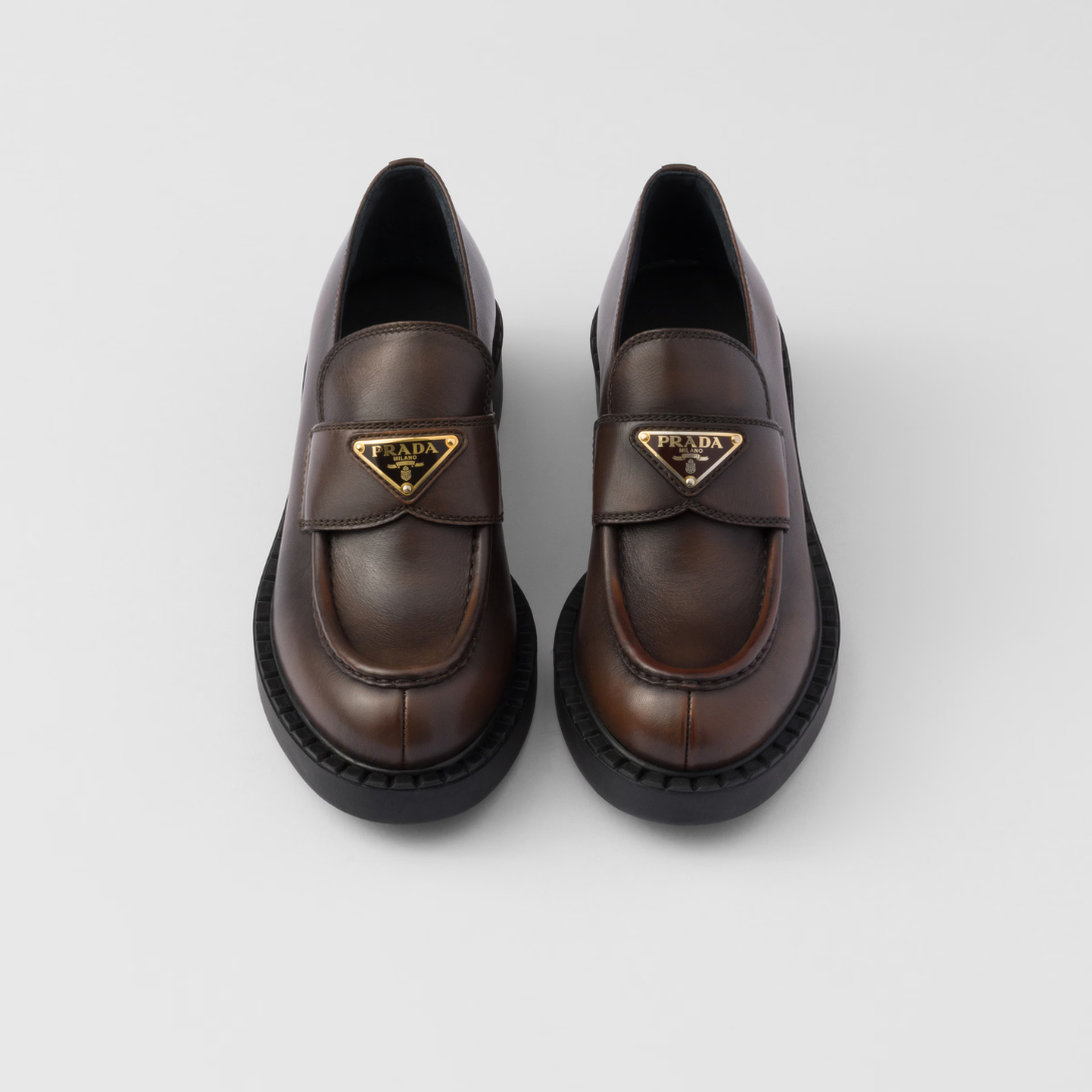 Chocolate leather loafers – the enameled metal triangle logo completes the iconic footwear – LUX VERSE Luxury Designer Fashion Outlet