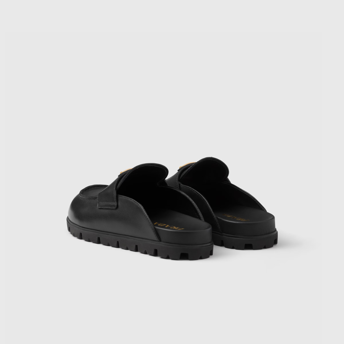Leather mules – the enameled metal triangle logo embellishes the leather band while the light rubber – LUX VERSE Luxury Designer Fashion Outlet