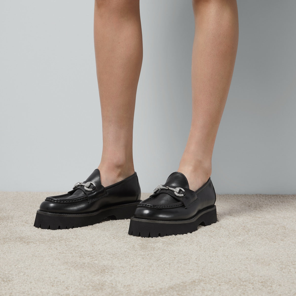 Women's lug sole loafer – a range of shimmering crystals enrich the emblem atop a black leather base – LUX VERSE Luxury Designer Fashion Outlet