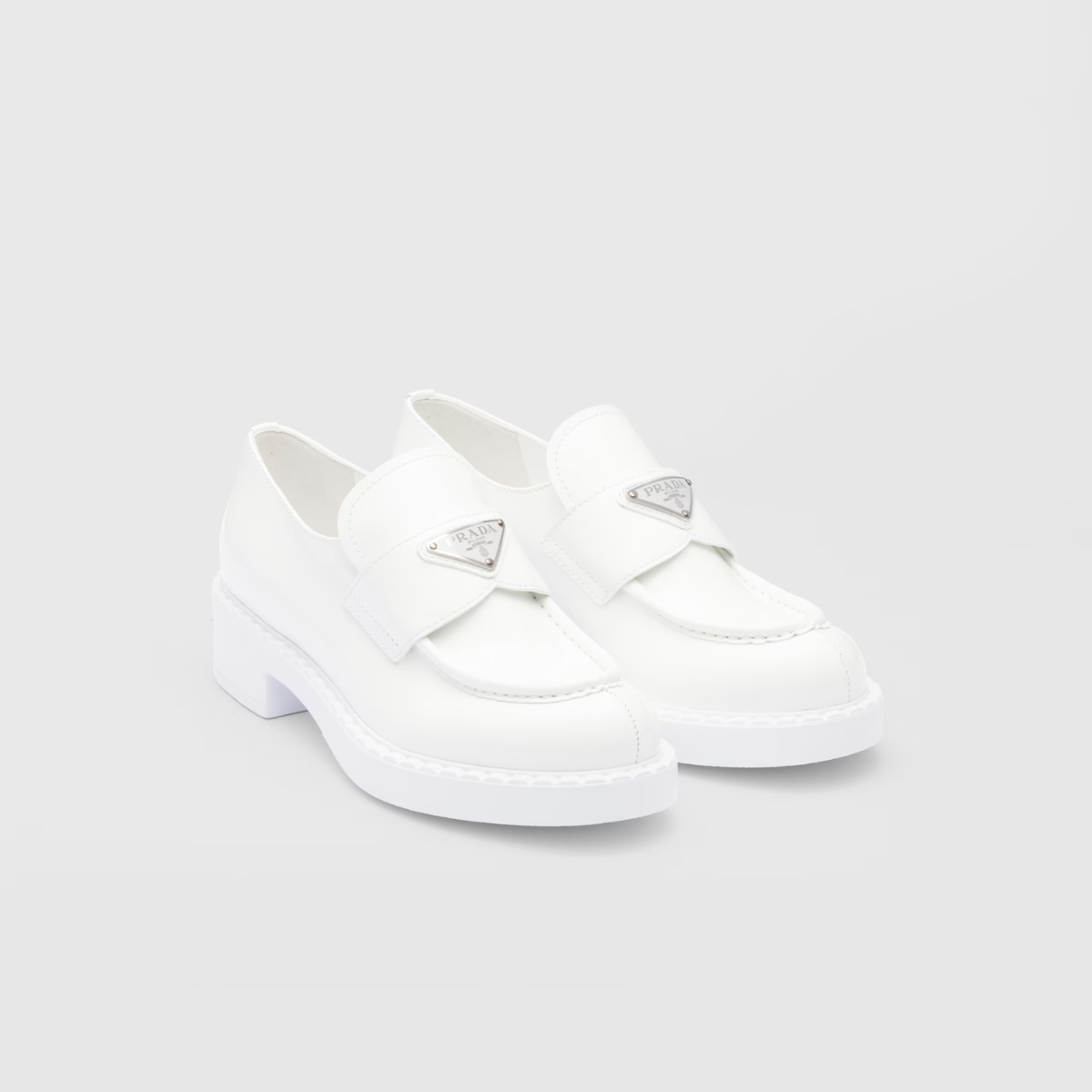 Chocolate patent leather loafers – the triangle logo, first introduced on trunks designed by Mario, decorates the front – LUX VERSE Luxury Designer Fashion Outlet
