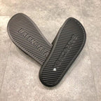 Schwarze Slides mit weißem Logo