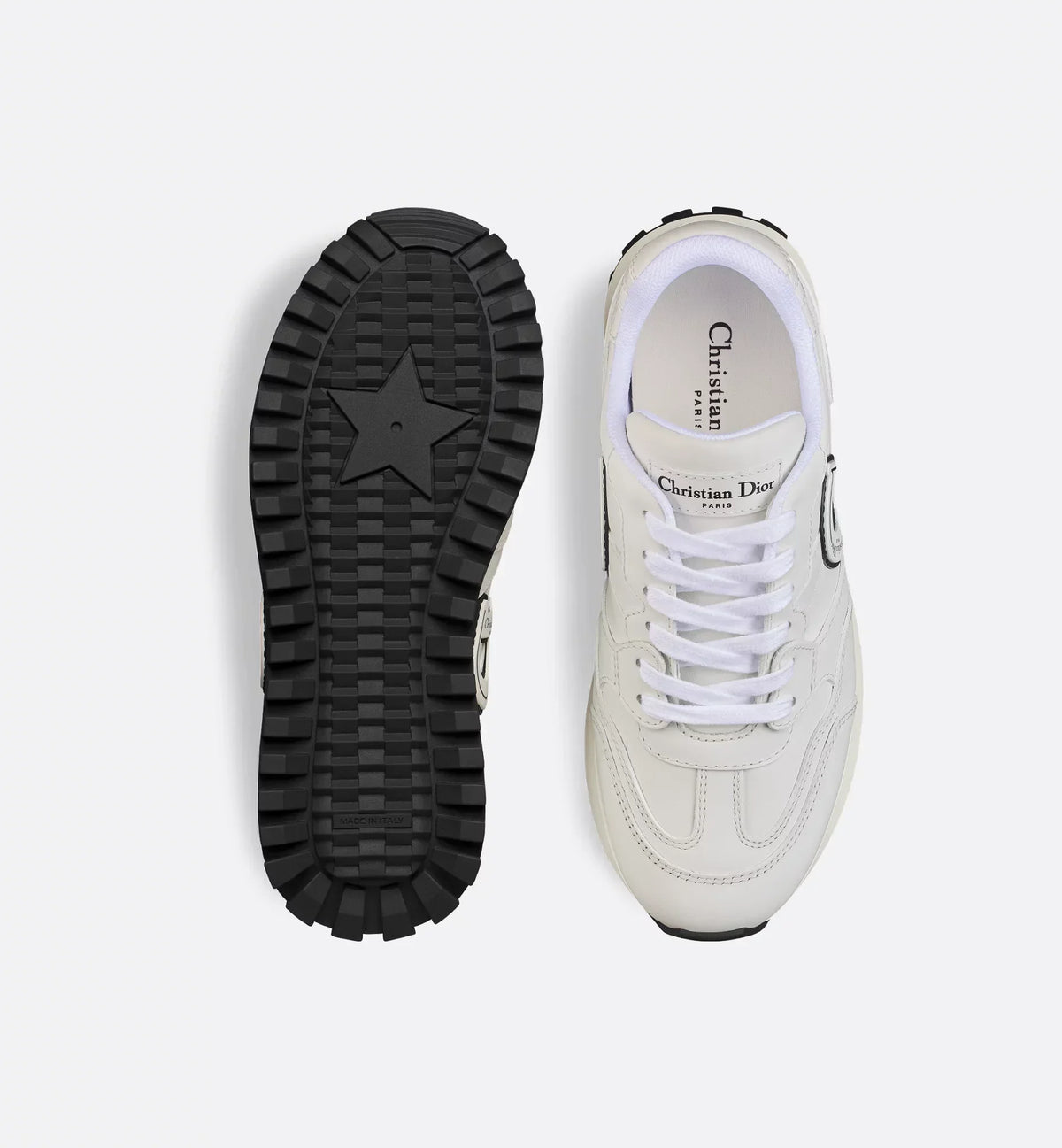 C'est Sneaker – the white calfskin is elevated on either side of the upper by black and white rubber – LUX VERSE Luxury Designer Fashion Outlet