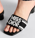 Dway Heeled Slide – the Dway heeled slide showcases the white Miss Graffiti motif, a nod to the 1967 – LUX VERSE Luxury Designer Fashion Outlet