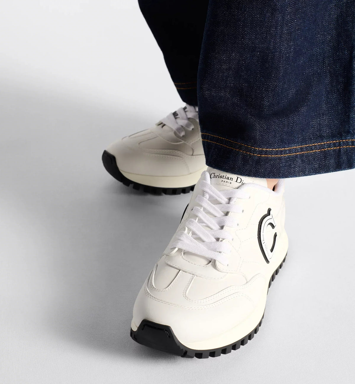 C'est Sneaker – the white calfskin is elevated on either side of the upper by black and white rubber – LUX VERSE Luxury Designer Fashion Outlet